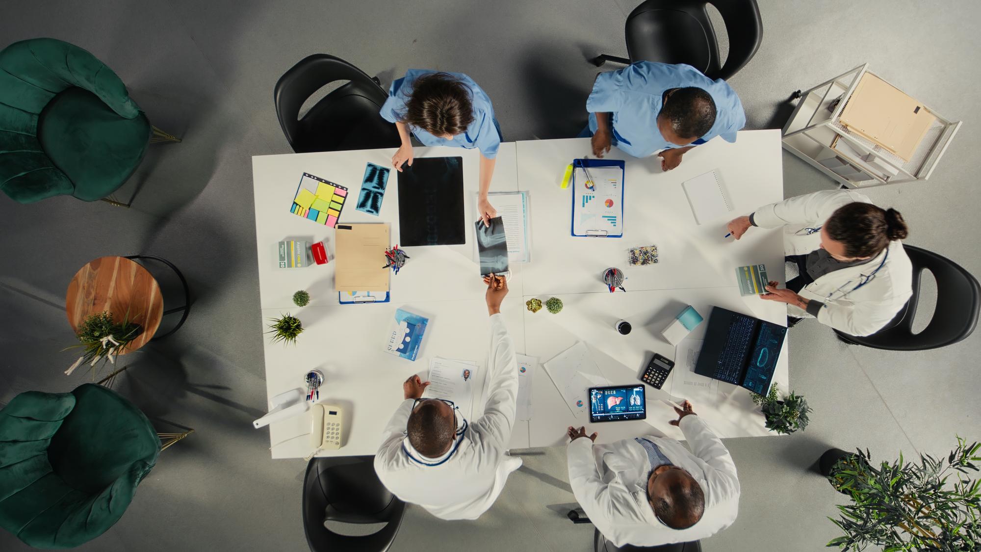 Group of colleagues planning a team trip at a table with maps and notes.